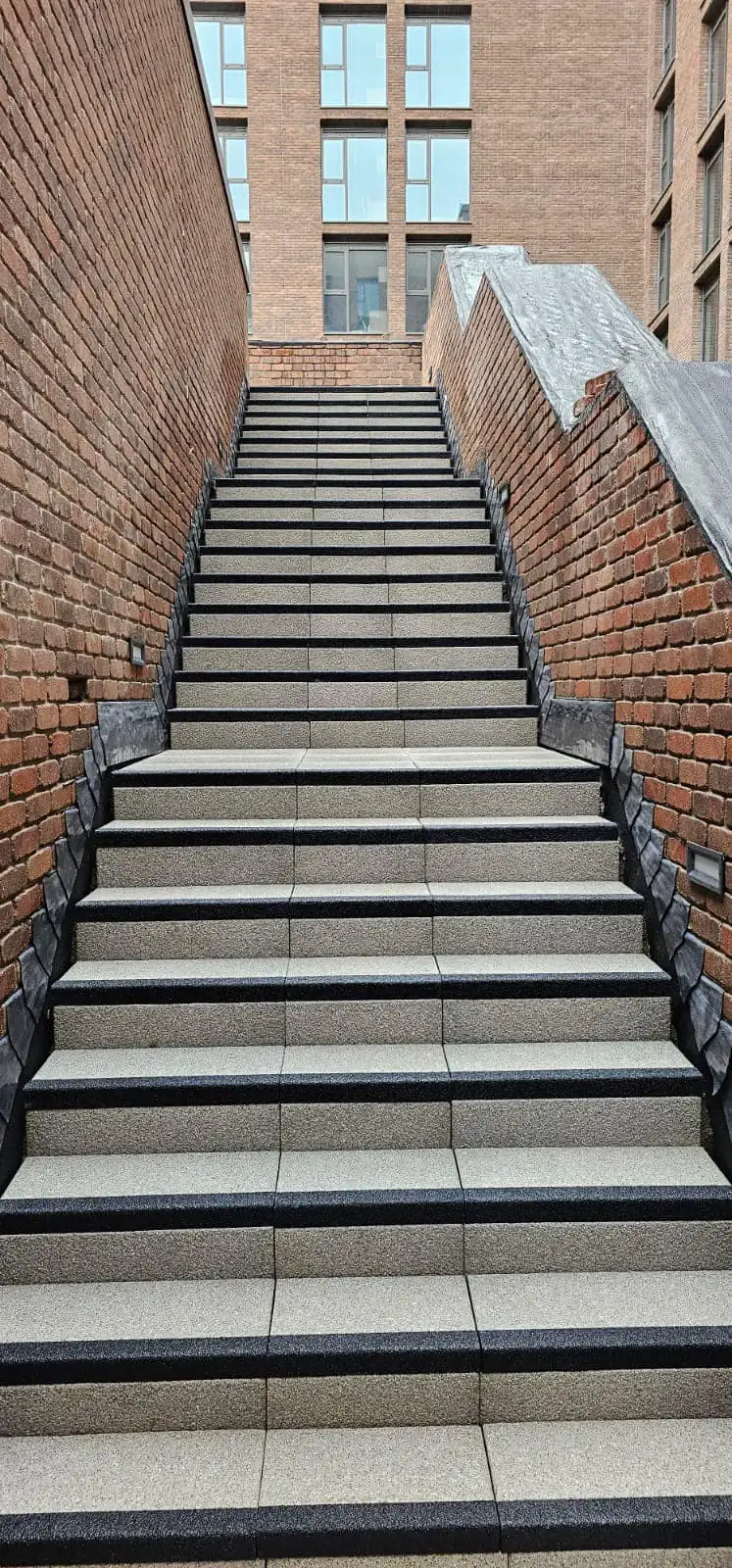 Large commercial staircase with granite treads and charcoal nosing