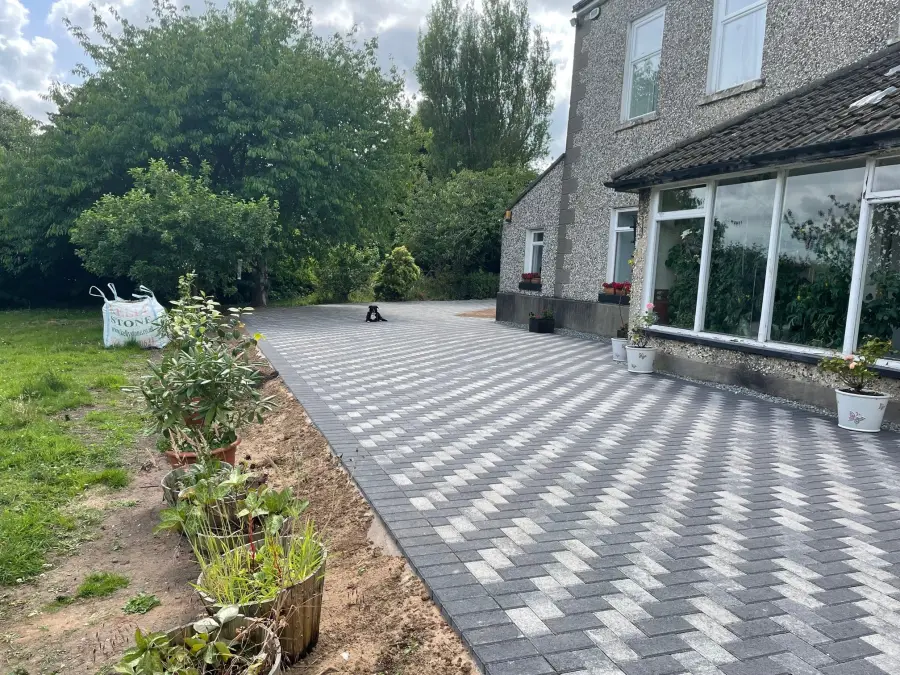 Large herringbone block paving area beside detached house